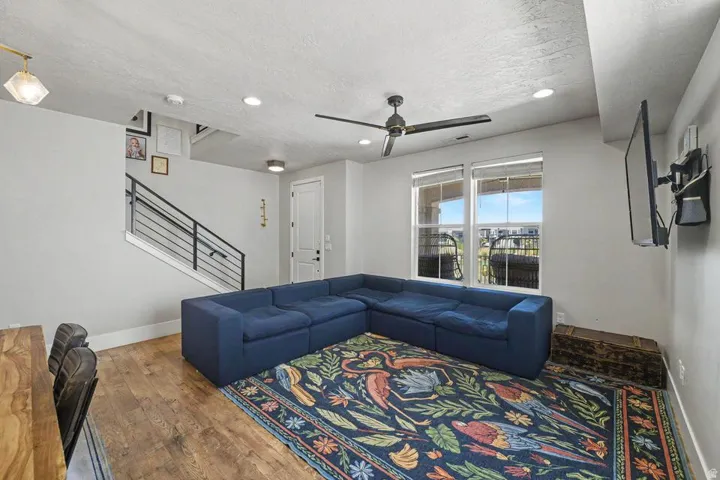 Open concept living area featuring wood-finish flooring, recessed lighting, and a contemporary ceiling fan