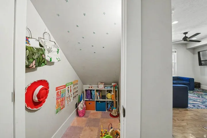 Under-stair alcove featuring an angled ceiling and light-colored walls