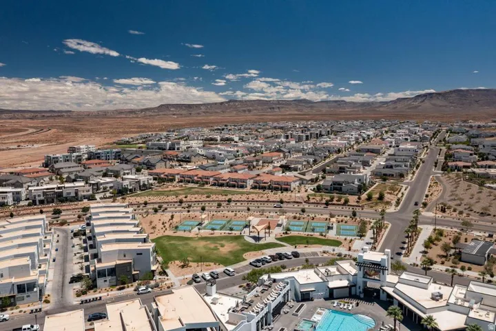 Expansive desert community featuring a central green space, multiple tennis courts, and a community pool area