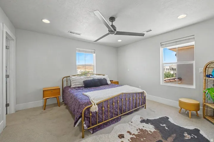 Light-toned walls with recessed lighting and a ceiling fan