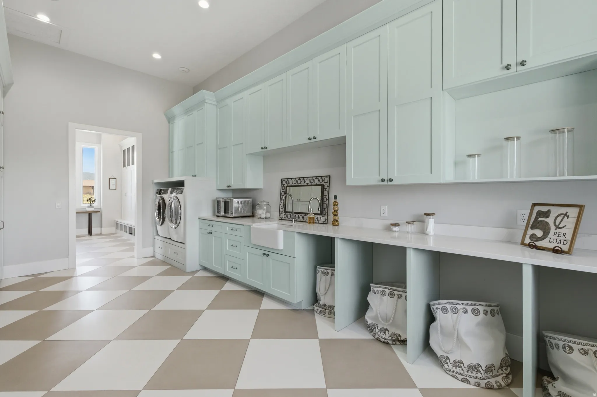 Laundry room featuring extensive light blue cabinetry, built-in utility sink, and white countertops