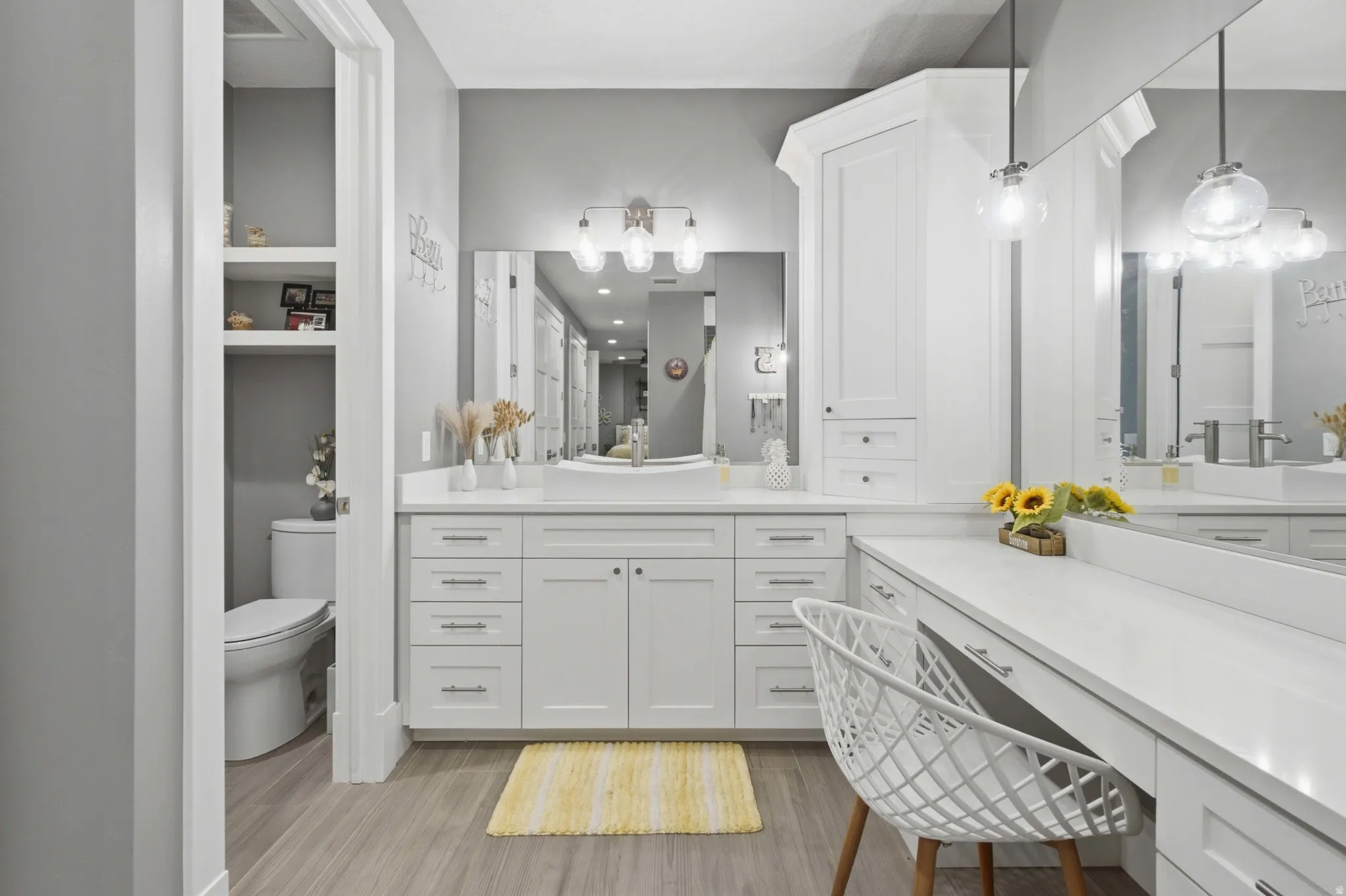 Spacious bathroom featuring an extended vanity with dual sinks, quartz countertops, and abundant white cabinetry