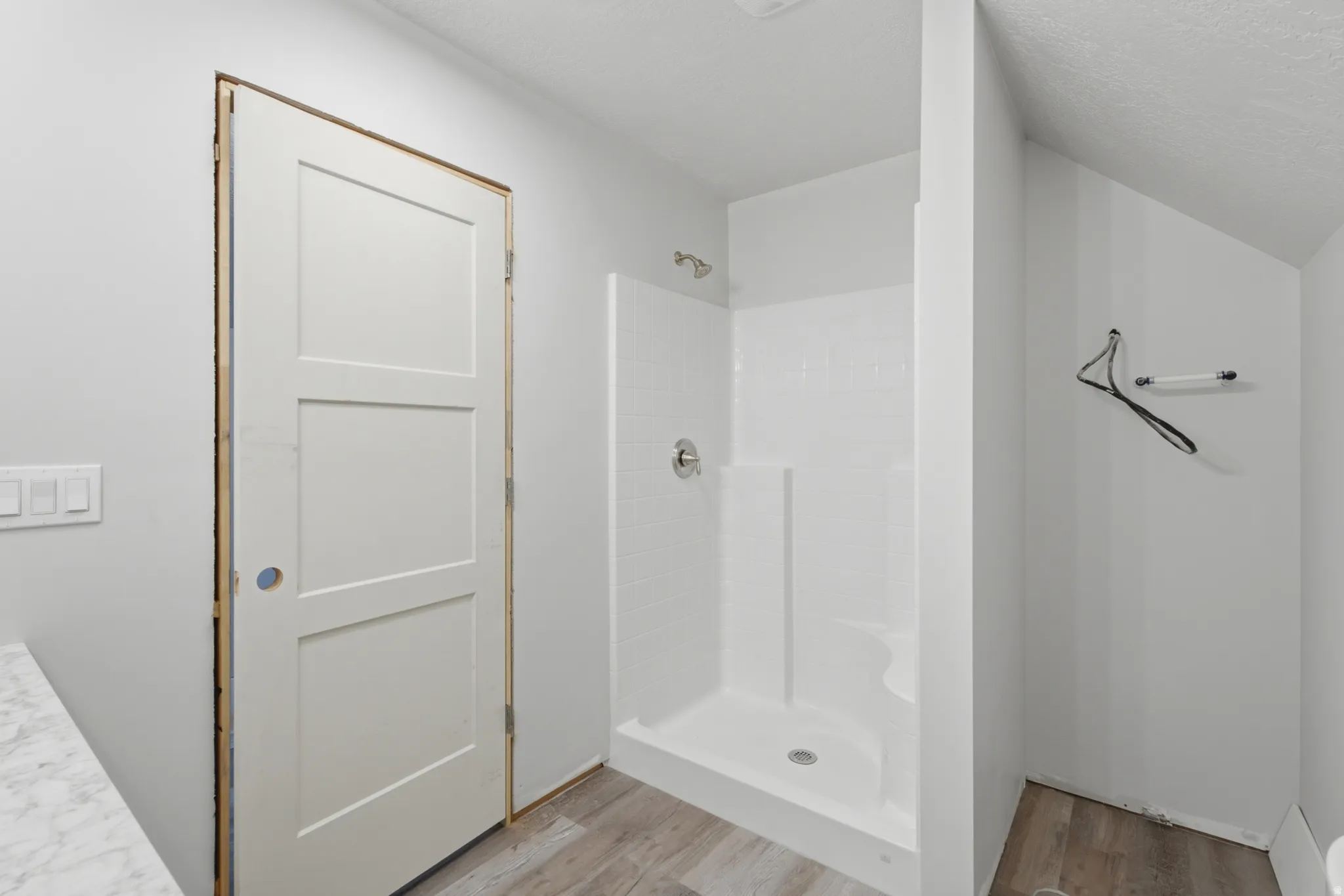 Bathroom featuring a standing shower with a built-in seat, a chrome showerhead, and a three-panel interior door