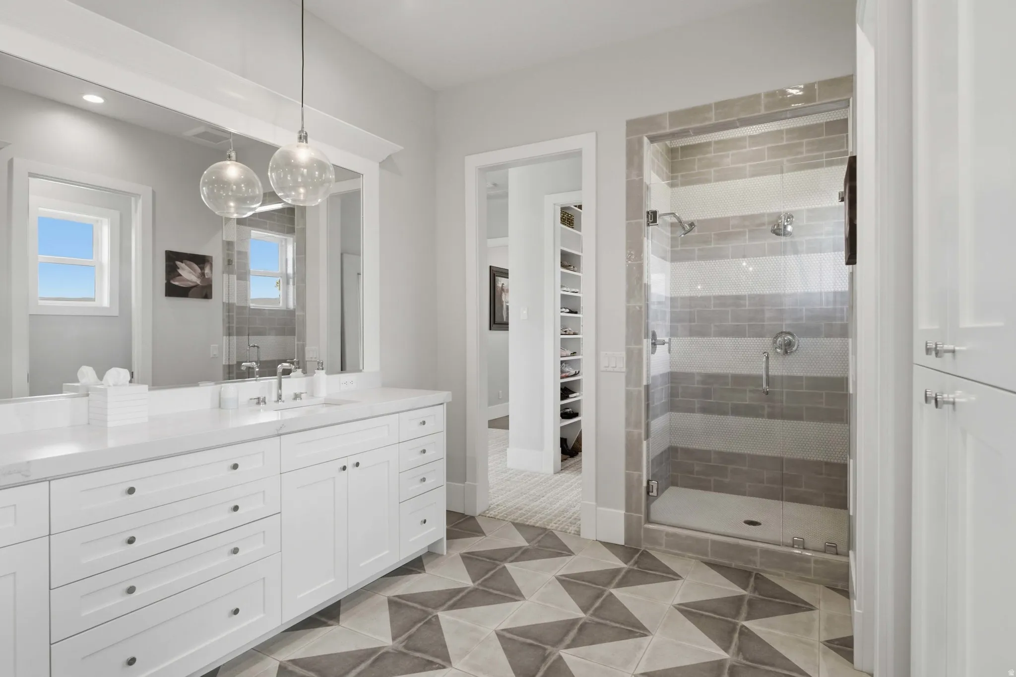 Double vanity with white cabinetry and a light-colored countertop