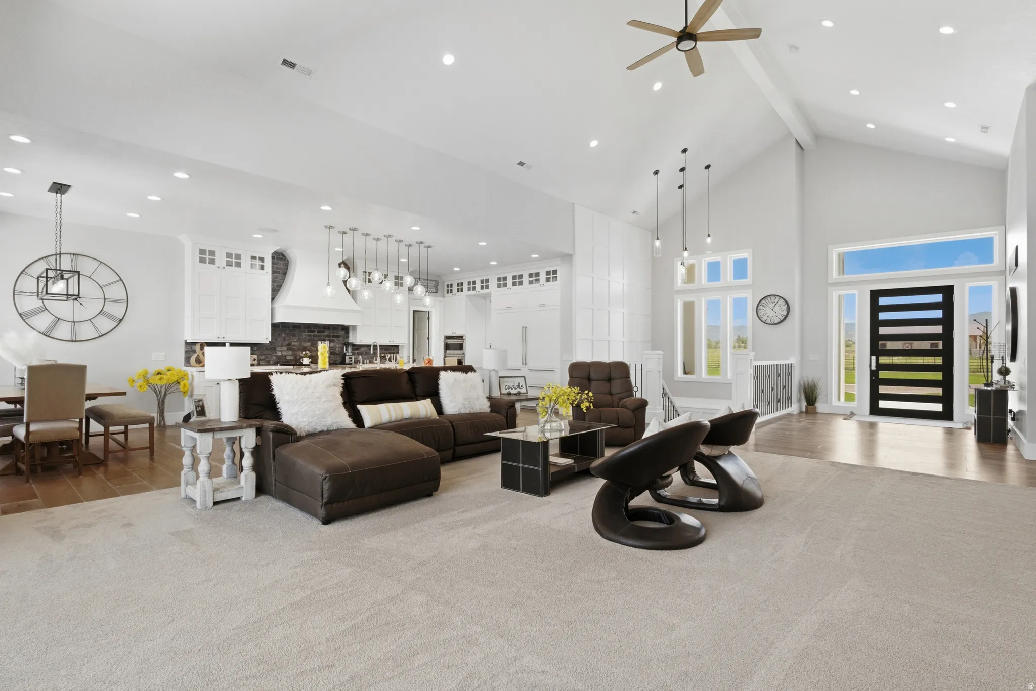 Vaulted ceiling great room featuring a modern front door, wood-finish flooring, recessed lighting, and a contemporary ceiling fan