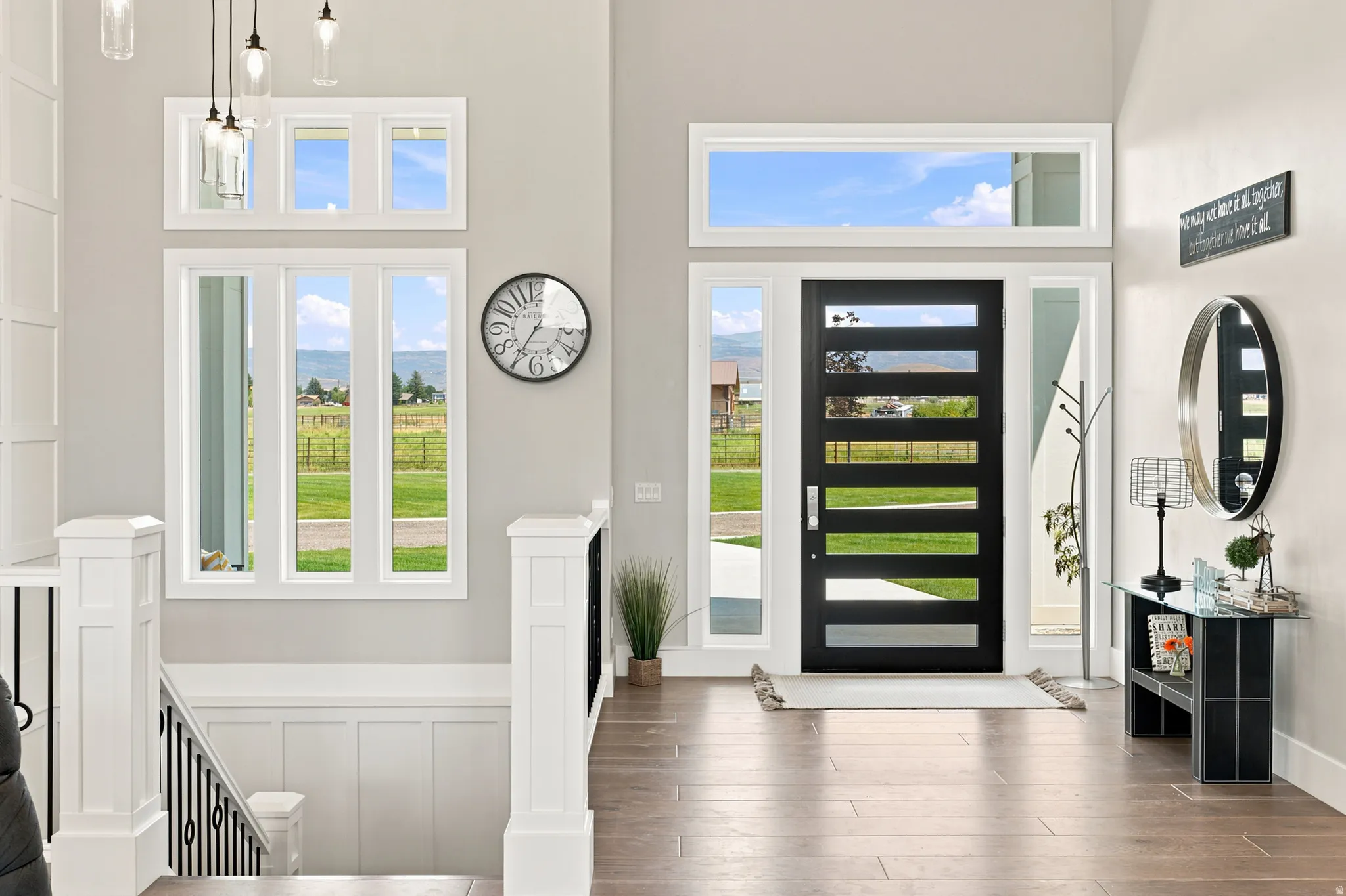 Contemporary entry door with five horizontal lites, flanked by sidelights and a transom window