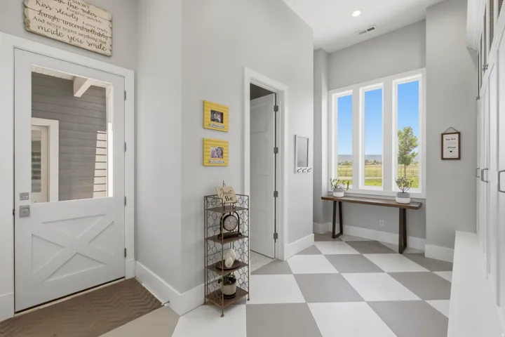 Entryway featuring a white Dutch door with clear glass panel, large picture windows, recessed lighting, and checkerboard floor tiles