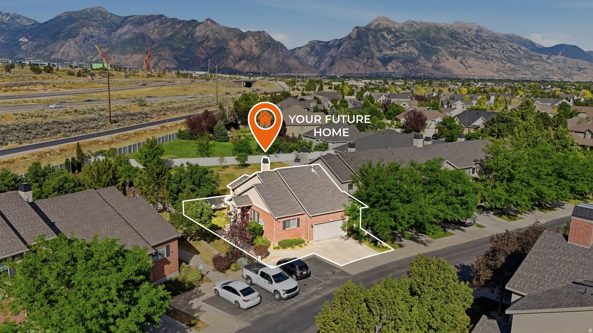 Brick exterior residence with an attached garage, a paved driveway, and mature landscaping