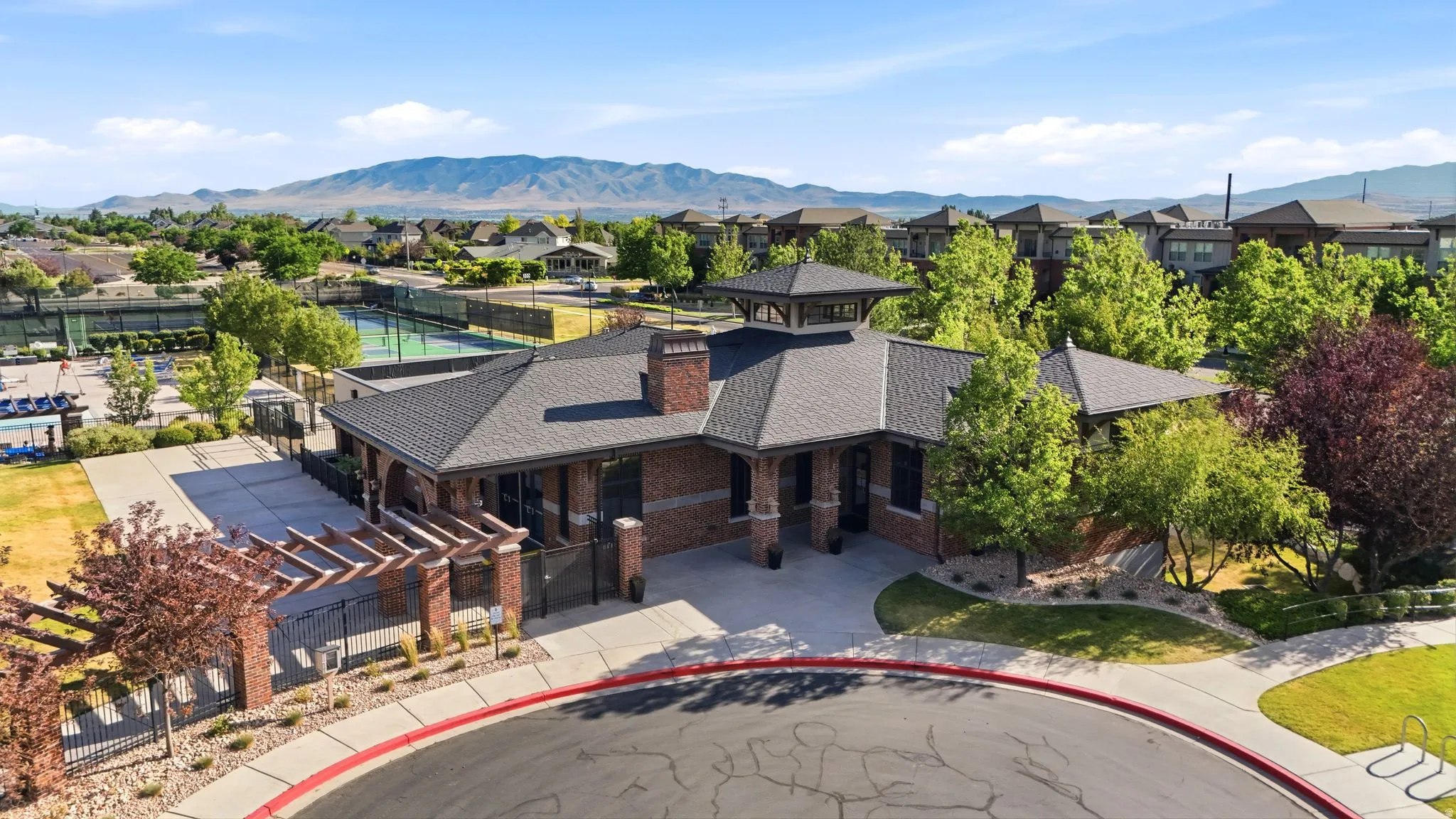Brick clubhouse building with a multi-gabled roof and cupola accent