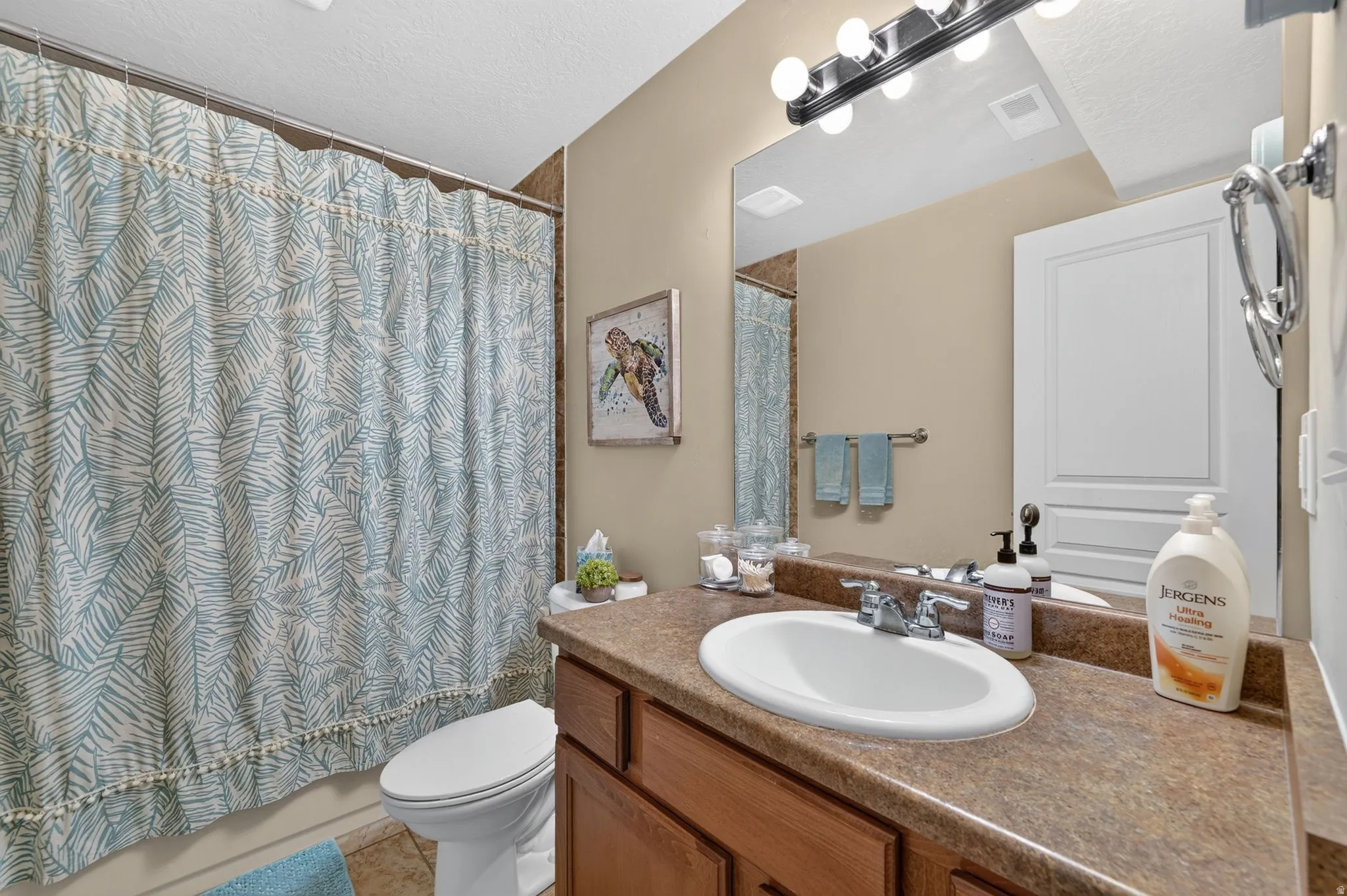 Bathroom vanity with an integrated oval sink, chrome faucet, and expansive mirror