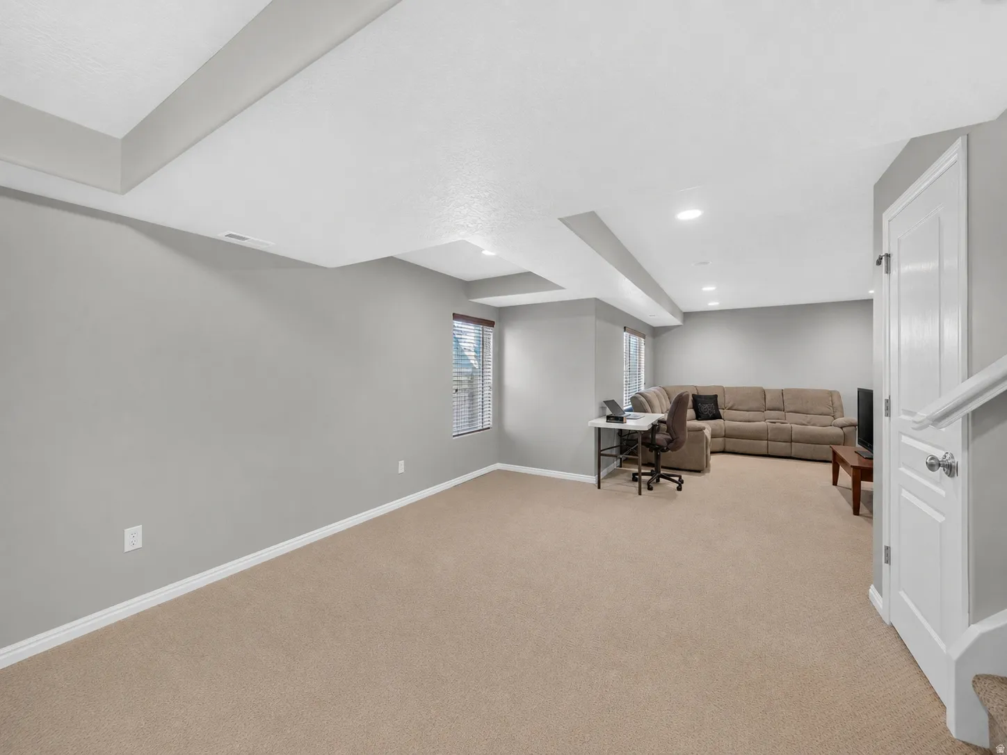 Spacious room featuring neutral carpeting and light gray walls