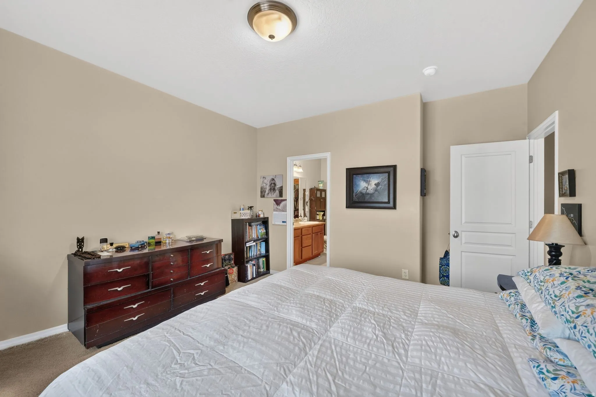 Carpeted bedroom featuring light beige wall paint and a flush-mount ceiling light