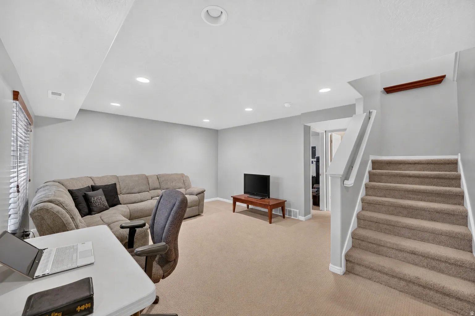 Carpeted staircase with white balustrade leading to an upper level