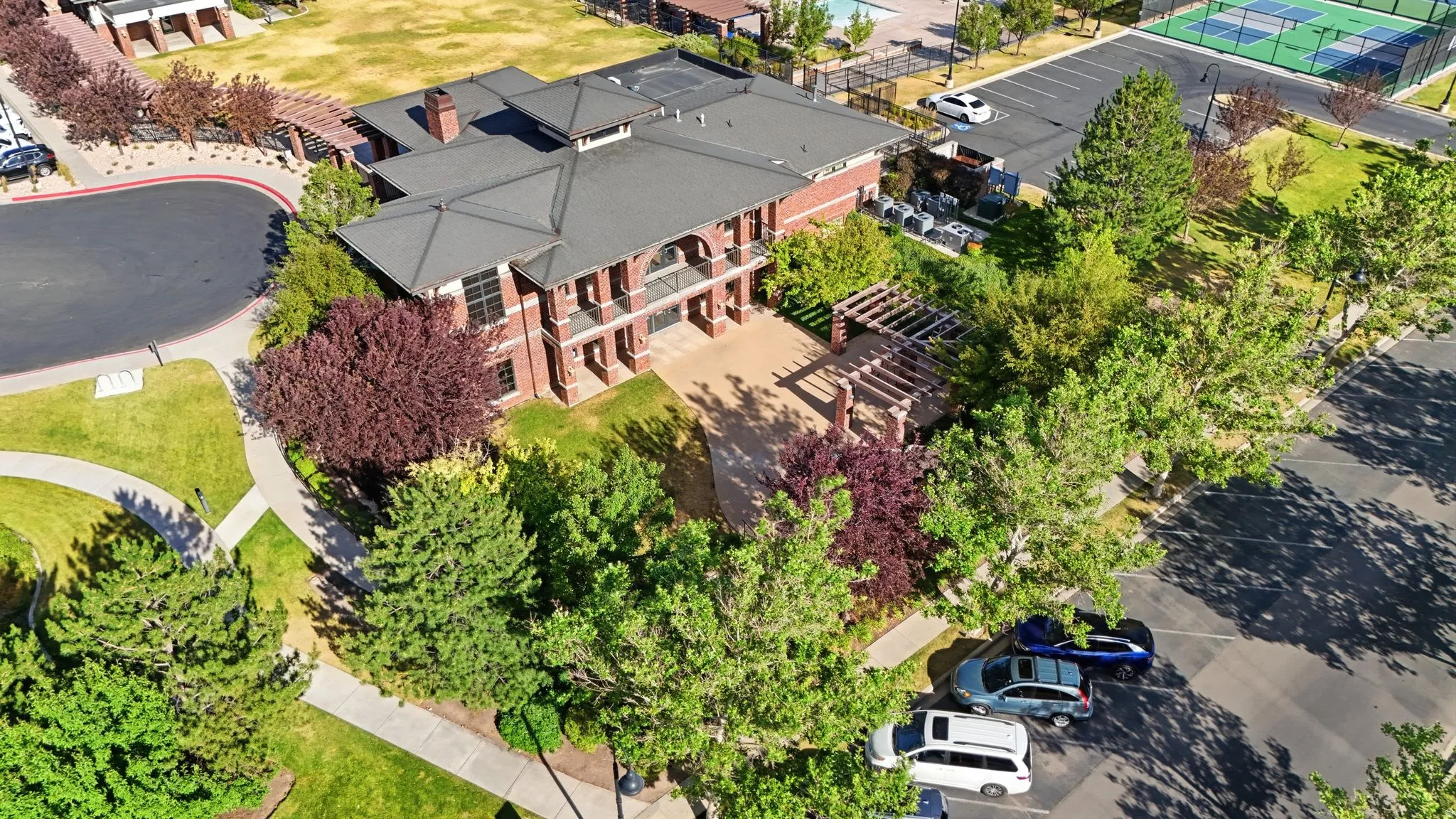 Brick exterior with multiple balconies, a covered patio, and pergolas