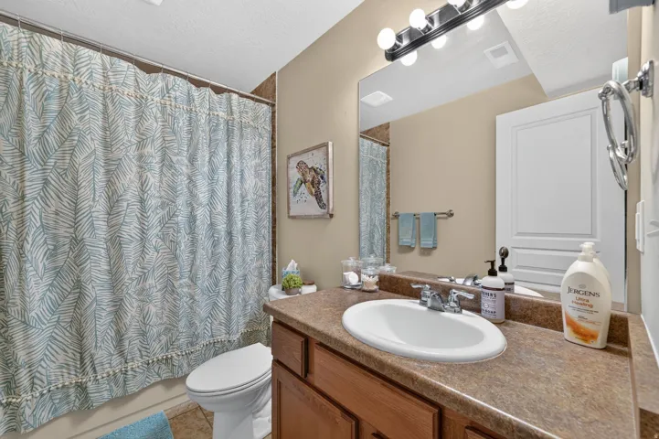 Bathroom vanity with an integrated oval sink, chrome faucet, and expansive mirror