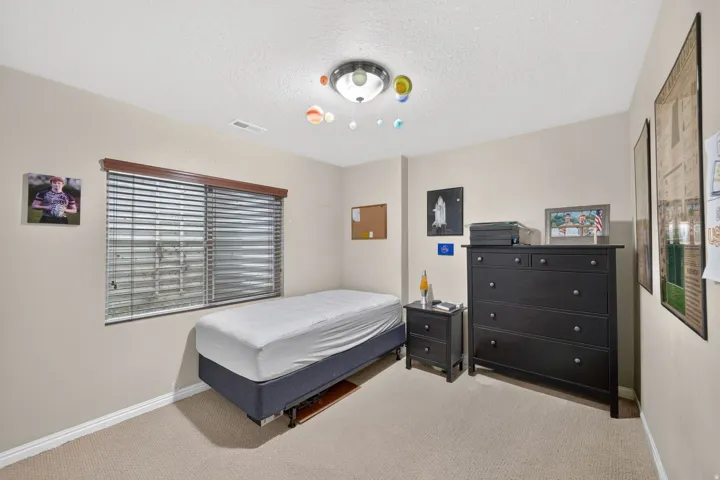 Carpeted room featuring a window with horizontal blinds and a wood valance