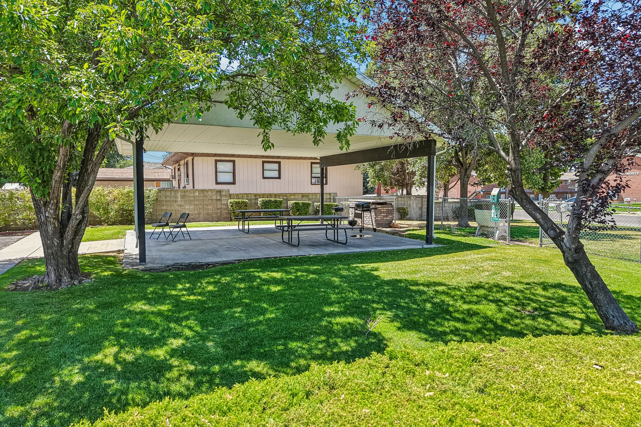 Covered outdoor patio space featuring a concrete slab and built-in barbecue area