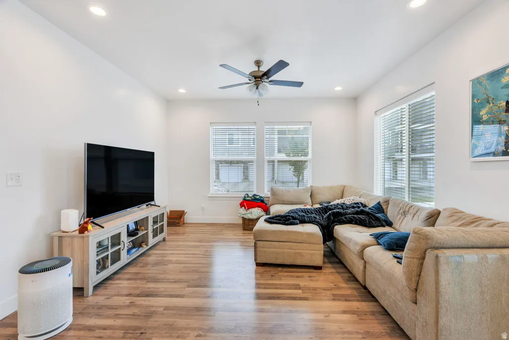 Spacious living area featuring wood-finish flooring, recessed lighting, and a ceiling fan