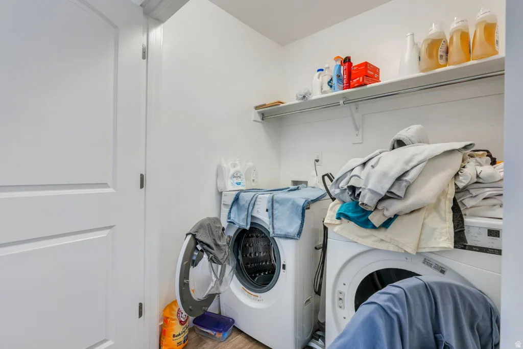 Dedicated laundry area featuring a built-in white shelving unit and wood-finish flooring