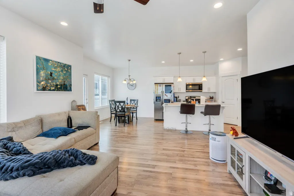 Open-concept living area featuring wood-finish flooring, vaulted ceilings, and recessed lighting