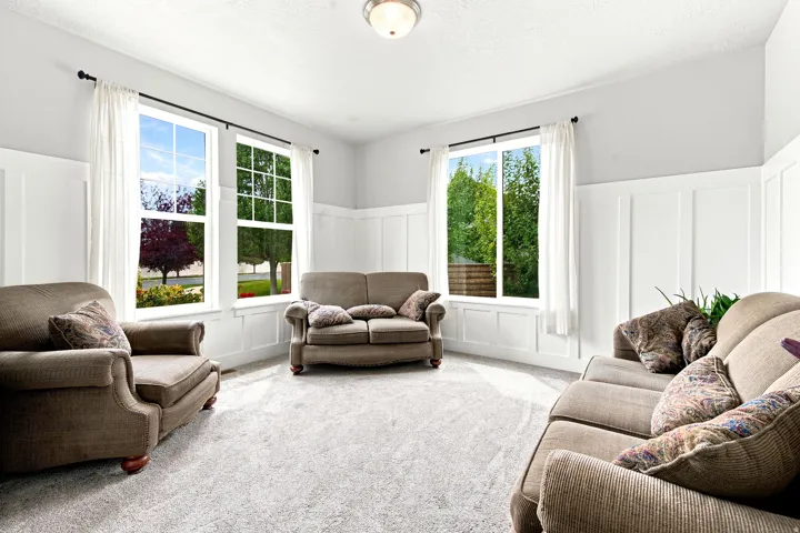 Spacious room with light gray walls, white board and batten paneling, and wall-to-wall carpeting