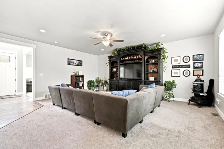 Spacious living area featuring light-toned carpeting and recessed lighting