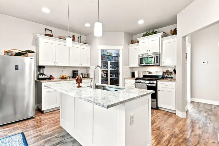 Central kitchen island with a granite countertop and undermount sink