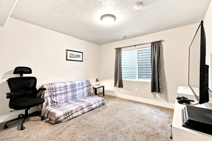 Carpeted room featuring a white-framed window with a window well
