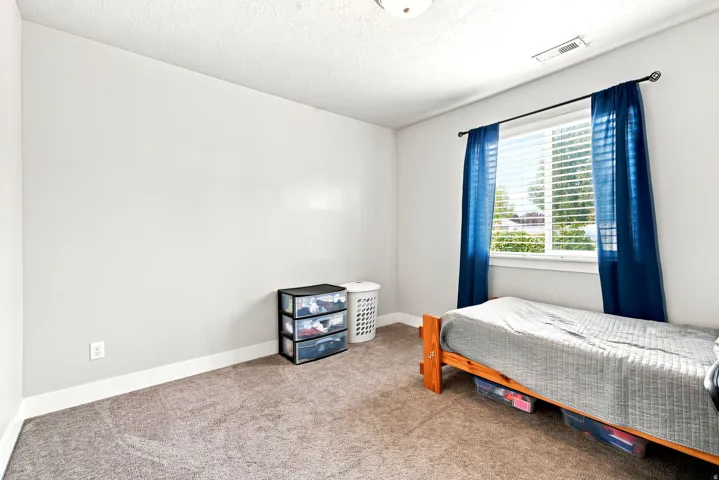 Carpeted room featuring a single window with blinds, white trim, and a ceiling light fixture