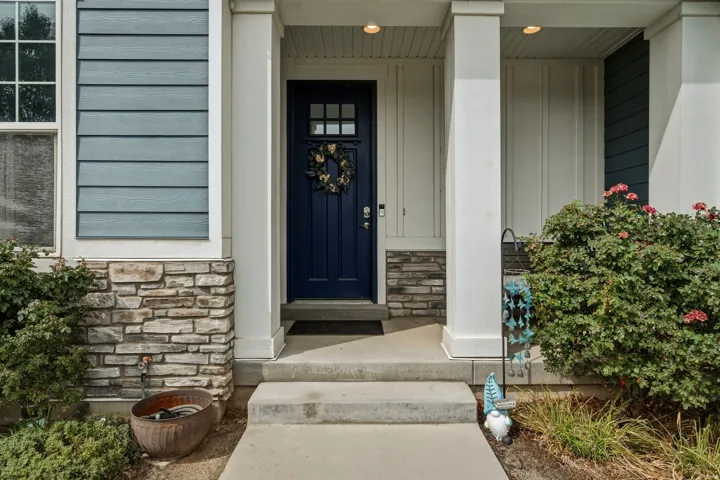 Inviting front entry featuring a deep blue paneled door with upper window panes