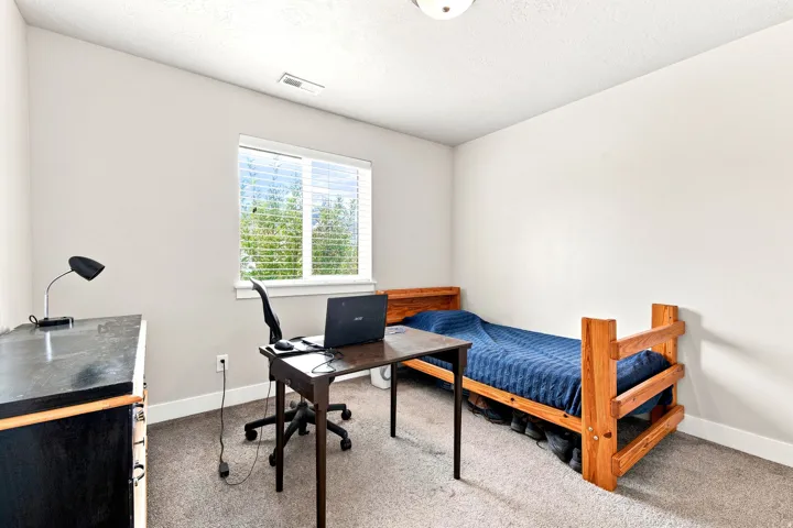 Neutral wall paint, window with blinds, carpeted flooring, and a ceiling light fixture