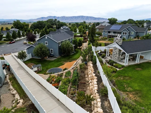 Expansive backyard featuring tiered landscaping with mature plantings and established garden beds