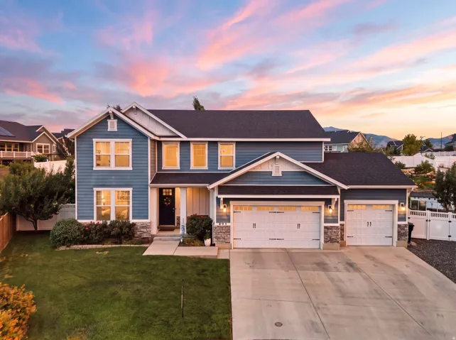Two-story residence featuring blue siding, white trim, and stone accents