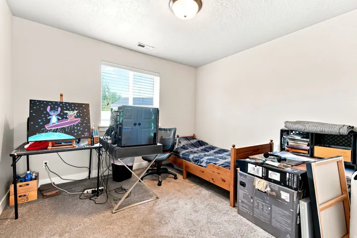 Neutral wall finishes complemented by textured carpeting and a single overhead light fixture
