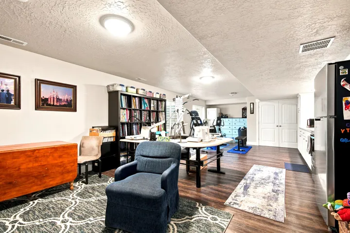 Open-concept living space featuring wood-finish flooring, recessed lighting, white walls, and built-in cabinetry