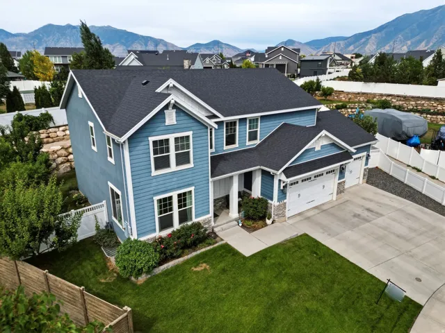 Two-story residence featuring blue siding, white trim, and a dark shingle roof