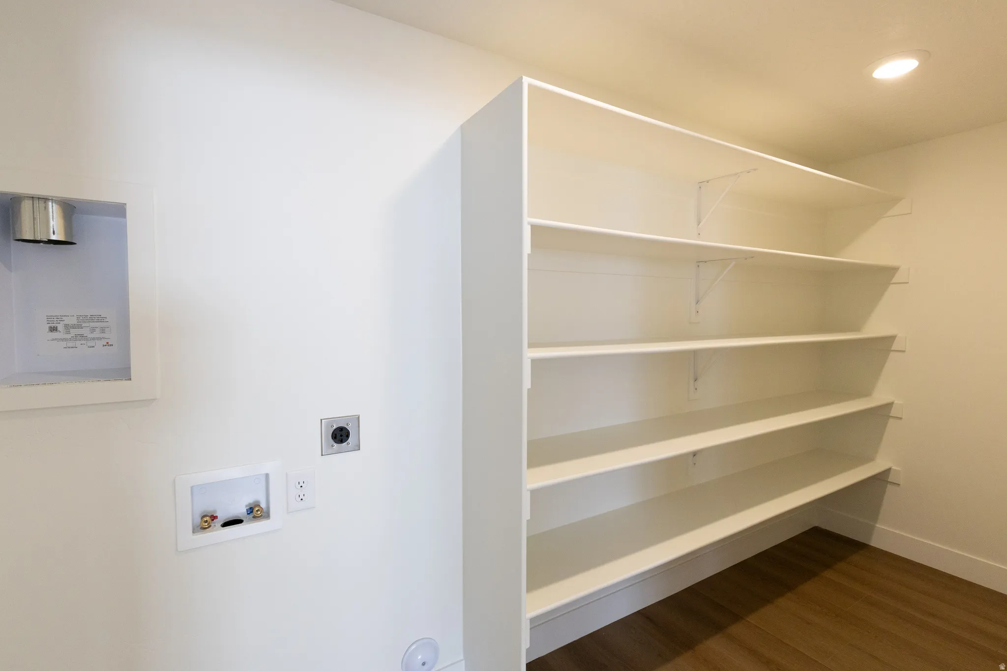 Integrated laundry hookups, built-in shelving, recessed lighting, and wood-finish flooring