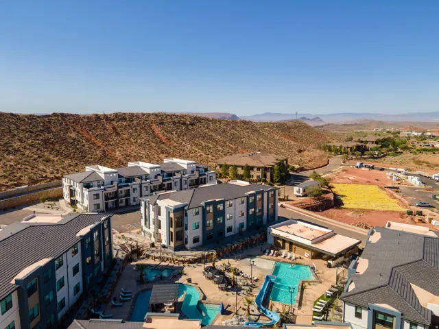 Resort-style pool area featuring multiple swimming pools, a water slide, and ample lounge seating