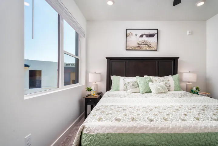 Bright bedroom featuring a large window with blinds, recessed lighting, and a ceiling fan