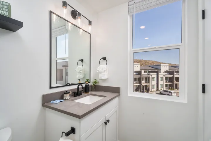 White vanity with dark stone countertop and integrated sink