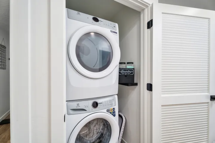 Dedicated laundry closet featuring a stacked washer and dryer unit