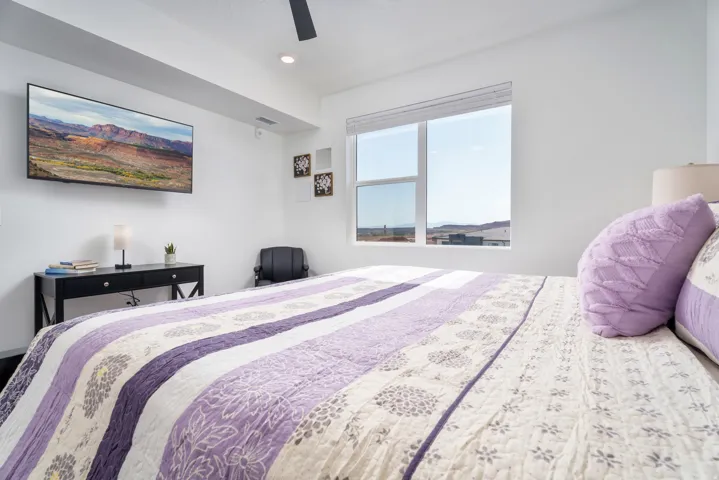 Spacious room featuring a large window, recessed lighting, and a ceiling fan