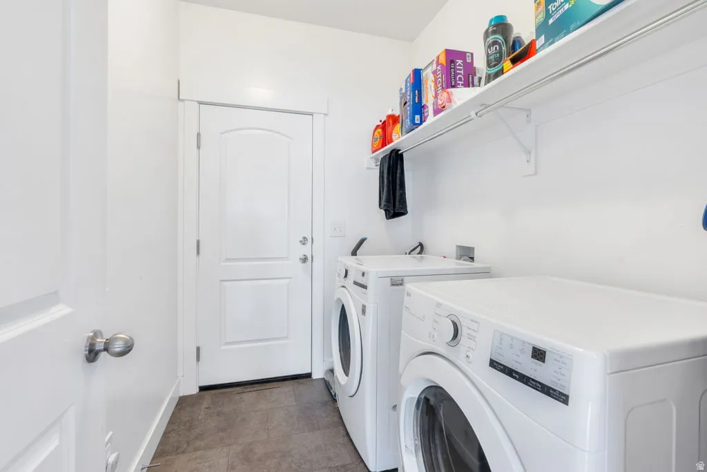 Practical laundry area featuring a white wall shelf, tile flooring, and a white paneled door