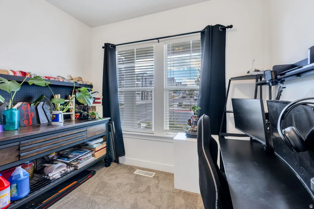 Bright room featuring a large window with blinds and dark curtains, carpeted flooring, and white painted walls