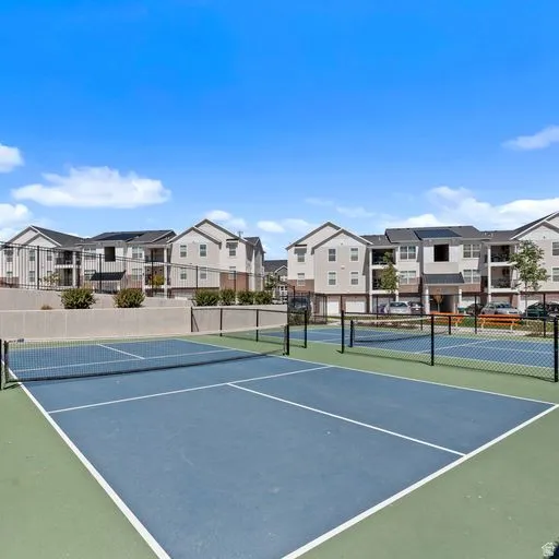 Outdoor hard-surface court featuring blue and green playing areas with white demarcation lines