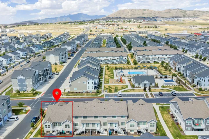 End-unit townhome featuring a multi-level exterior, two private balconies, and a fenced yard