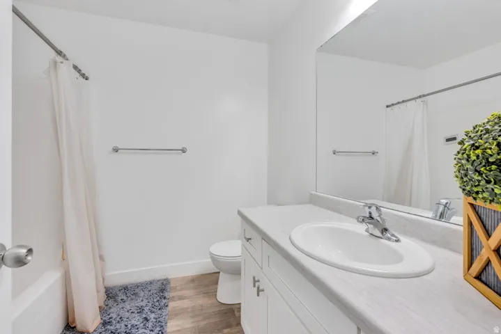 Bathroom featuring a white vanity with an integrated sink, polished chrome faucet, and a large wall-mounted mirror