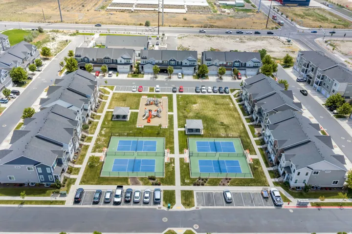 Central green space featuring two tennis courts, a playground area, a gazebo, and manicured lawns