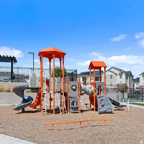 Dedicated play area featuring multi-level structures, spiral slides, climbing elements, and protective ground cover