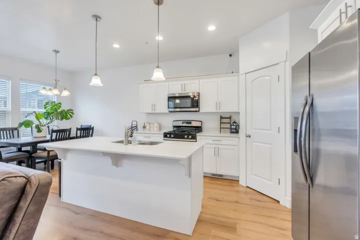 Kitchen featuring a large island with an undermount sink and two pendant lights